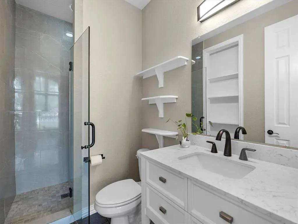 Before: Bathroom remodel in Rosedale, Austin, TX with a white shaker vanity and corner shower