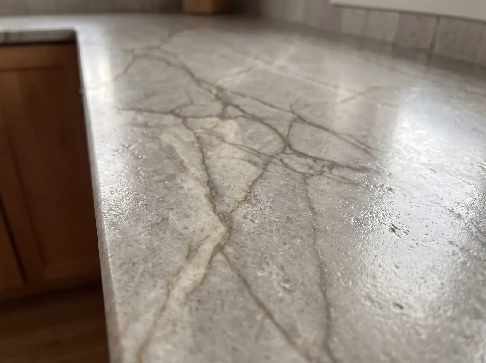 Quartzite countertop close-up with warm grey veining and leathered texture