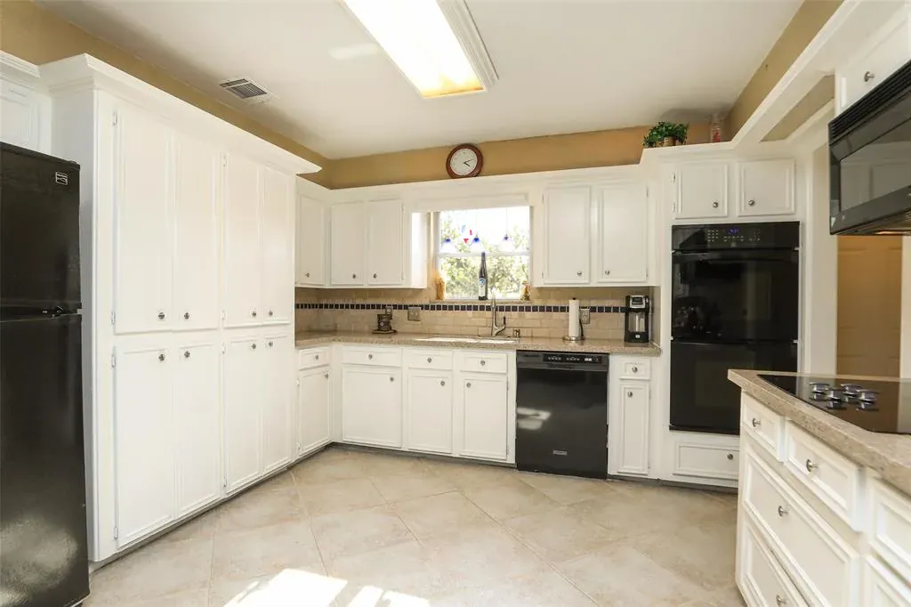 Before: Kitchen remodel in Travis Heights, Austin, TX with white cabinets and black appliances