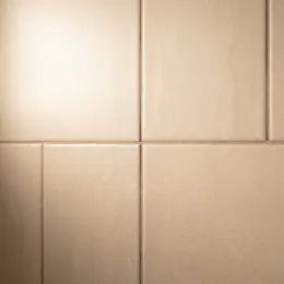 Finished warm neutral wall tile with tight grout joints